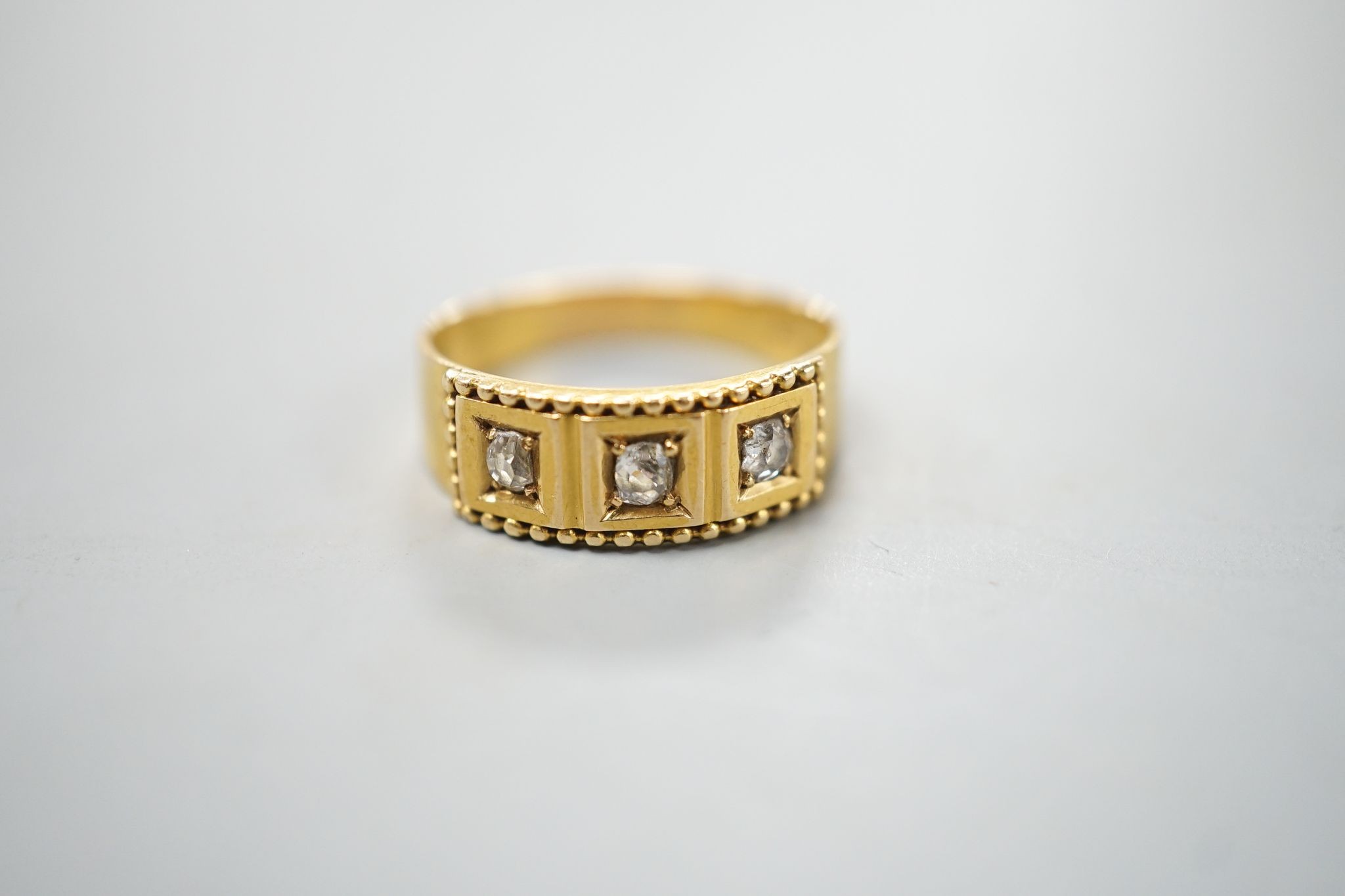 An 18ct and gypsy set three stone diamond ring, size M, gross 3.7 grams.